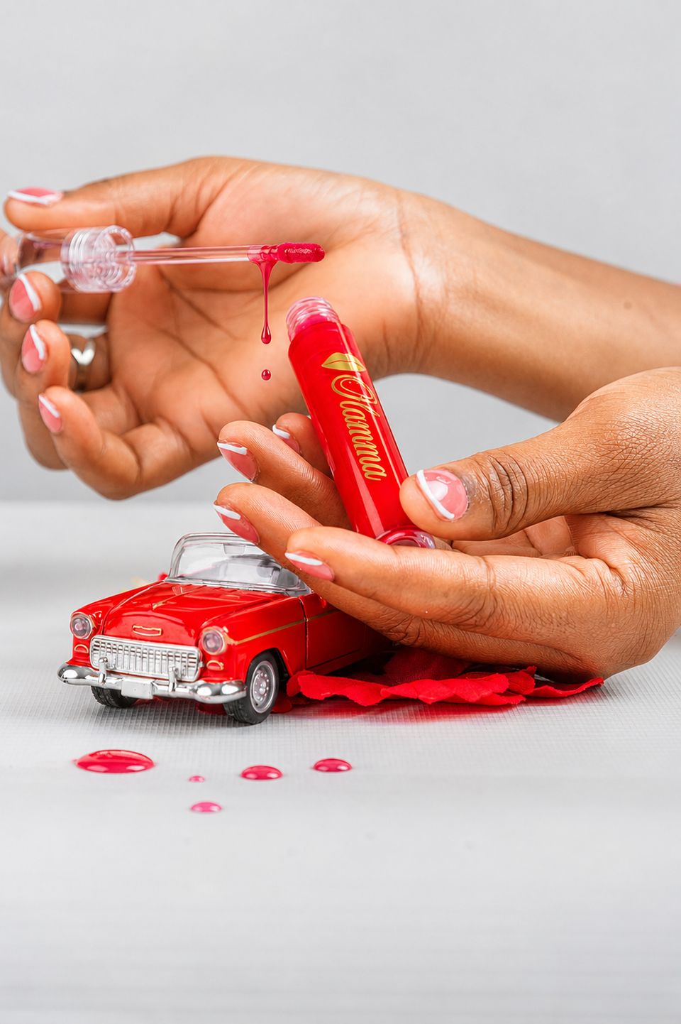 Hands pouring red gloss over a toy car