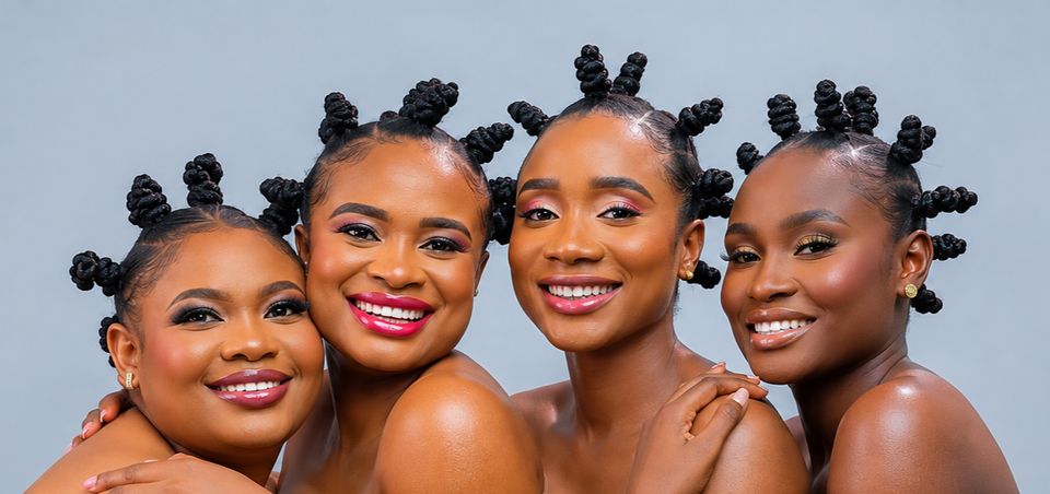 Four smiling women with bantu knots wearing OLAMMA gloss shades
