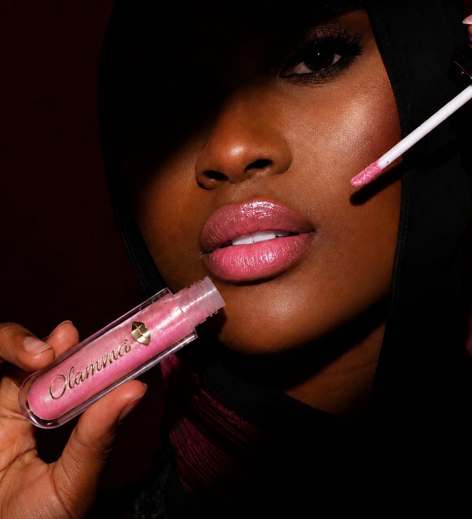Woman in a hood applying shimmer gloss