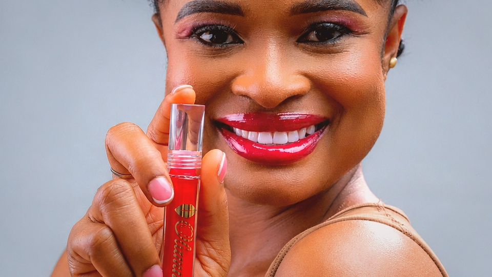 Smiling woman holding a red Ugo tube